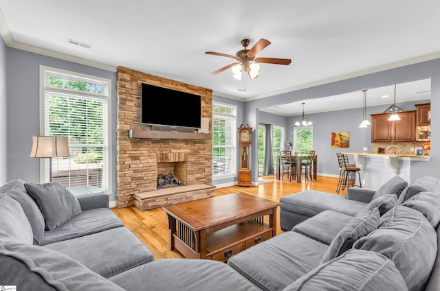 911 Devenger Rd, Greer, SC 29650 - living room featuring light wood-style flooring, ceiling fan, crown molding, and a stone fireplace