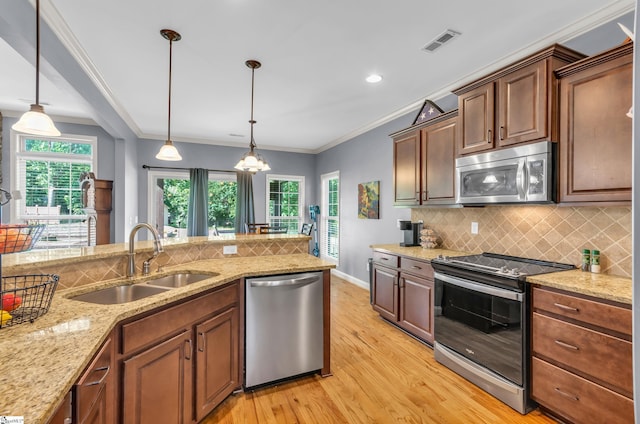 911 Devenger Rd, Greer, SC 29650 - kitchen featuring stainless steel appliances, light wood-style flooring, decorative backsplash, pendant lighting, and ornamental molding