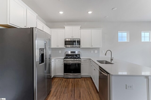 125 Magnolia St, Reidville, SC 29388 - kitchen featuring appliances with stainless steel finishes, a peninsula, dark wood-style flooring, light countertops, and white cabinetry