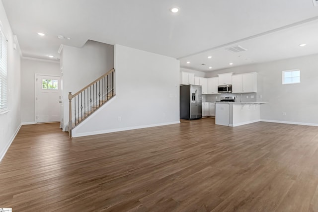 125 Magnolia St, Reidville, SC 29388 - unfurnished living room with dark wood finished floors, stairway, and recessed lighting