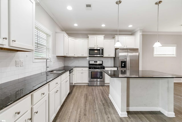 177 Viewmont Dr, Duncan, SC 29334 - kitchen with appliances with stainless steel finishes, crown molding, light wood finished floors, white cabinetry, and backsplash