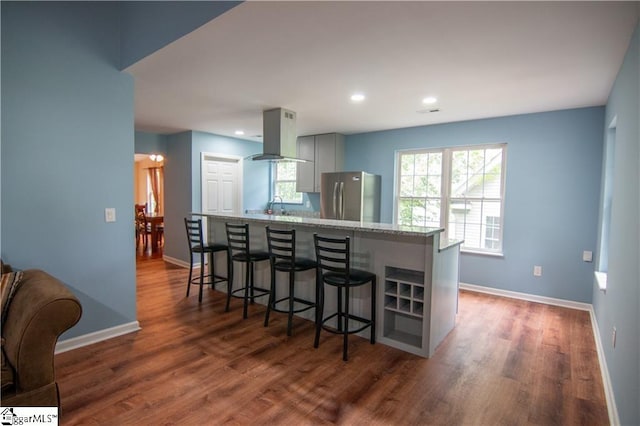 124 Grand Oak Dr, Pendleton, SC 29670 - kitchen with freestanding refrigerator, island range hood, dark wood finished floors, a kitchen breakfast bar, and light stone countertops