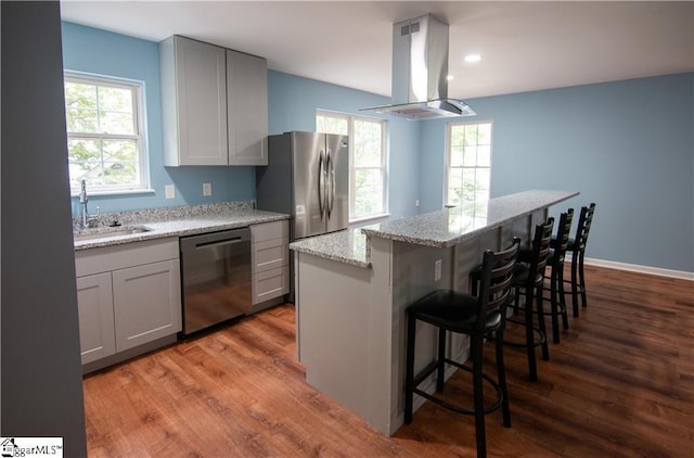 124 Grand Oak Dr, Pendleton, SC 29670 - kitchen with appliances with stainless steel finishes, island range hood, wood finished floors, a kitchen bar, and recessed lighting