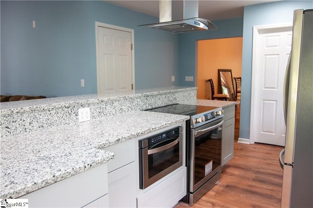 124 Grand Oak Dr, Pendleton, SC 29670 - kitchen featuring exhaust hood, appliances with stainless steel finishes, light wood-style floors, white cabinetry, and light stone counters