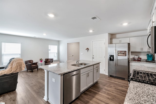 1808 Bridle Ln, Roebuck, SC 29376 - kitchen with appliances with stainless steel finishes, open floor plan, dark wood-style floors, a center island with sink, and light stone countertops