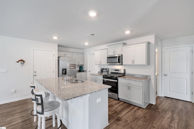 1808 Bridle Ln, Roebuck, SC 29376 - kitchen with stainless steel appliances, a breakfast bar area, an island with sink, dark wood-style flooring, and recessed lighting