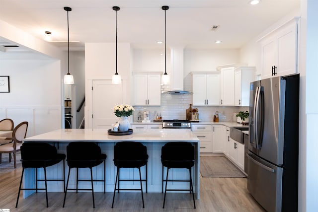 140 Holmes Dr, Spartanburg, SC 29303 - kitchen featuring stainless steel appliances, wall chimney range hood, light wood finished floors, white cabinets, and recessed lighting