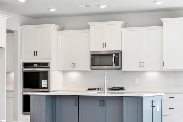 913 Wild Pine Ct, Duncan, SC 29334 - kitchen with appliances with stainless steel finishes, light countertops, an island with sink, white cabinets, and recessed lighting