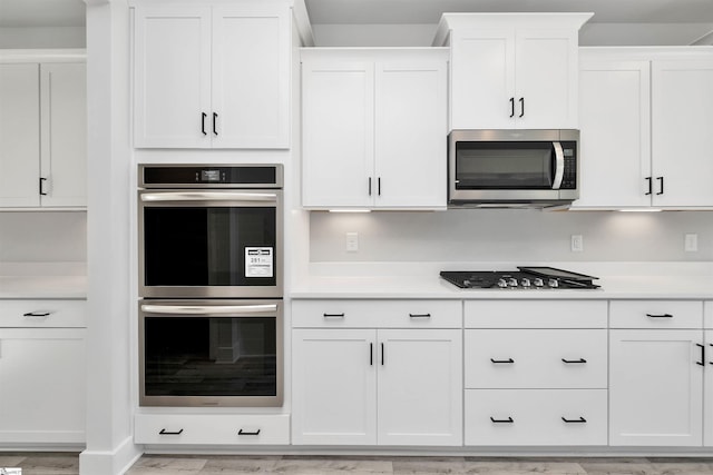 913 Wild Pine Ct, Duncan, SC 29334 - kitchen featuring stainless steel appliances, white cabinets, light countertops, and light wood-style flooring