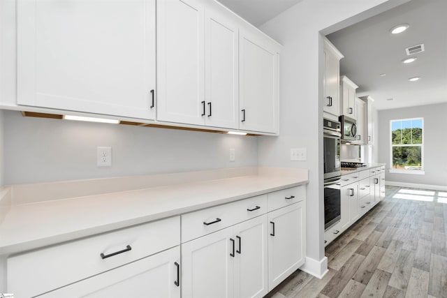 913 Wild Pine Ct, Duncan, SC 29334 - kitchen with light wood-type flooring, white cabinets, appliances with stainless steel finishes, light countertops, and recessed lighting