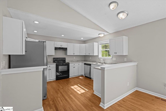 263 Cornelson Dr, Greer, SC 29651 - kitchen with stainless steel appliances, under cabinet range hood, light wood-type flooring, vaulted ceiling, and white cabinetry