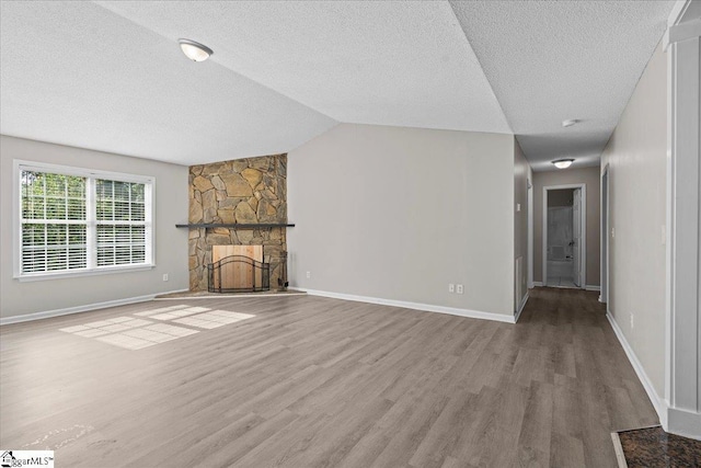 263 Cornelson Dr, Greer, SC 29651 - unfurnished living room featuring wood finished floors, a textured ceiling, a fireplace, and lofted ceiling