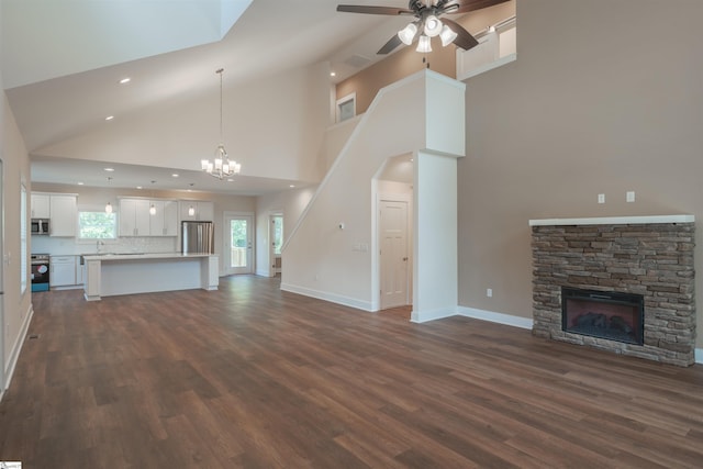 18003 Clermont Cir, Seneca, SC 29678 - unfurnished living room featuring high vaulted ceiling, a stone fireplace, dark wood finished floors, a ceiling fan, and a chandelier