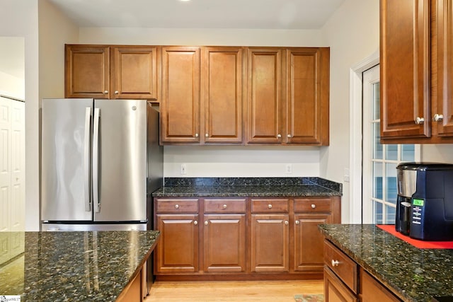 108 Myrtle Way, Greer, SC 29650 - kitchen with freestanding refrigerator, dark stone countertops, light wood-style flooring, and brown cabinetry