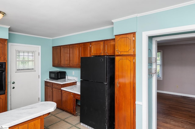 106 Thackston St, Fountain Inn, SC 29644 - kitchen featuring black appliances, light countertops, brown cabinetry, crown molding, and light wood-style flooring