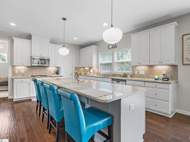 711 Hatwood Ct, Duncan, SC 29334 - kitchen featuring appliances with stainless steel finishes, a kitchen island, white cabinetry, recessed lighting, and dark wood-type flooring