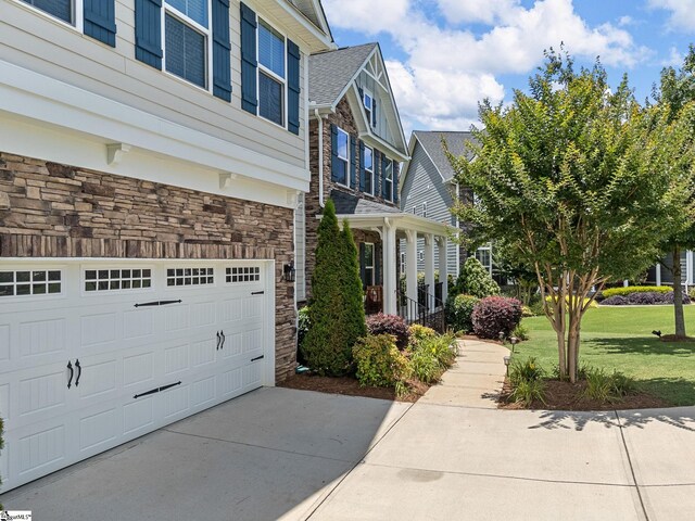 711 Hatwood Ct, Duncan, SC 29334 - view of property exterior featuring stone siding, a garage, a yard, and concrete driveway