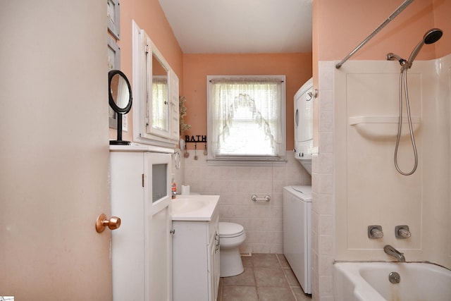 204 Jasper St, Easley, SC 29640 - bathroom with stacked washer and clothes dryer, vanity, tile patterned floors, washtub / shower combination, and tile walls