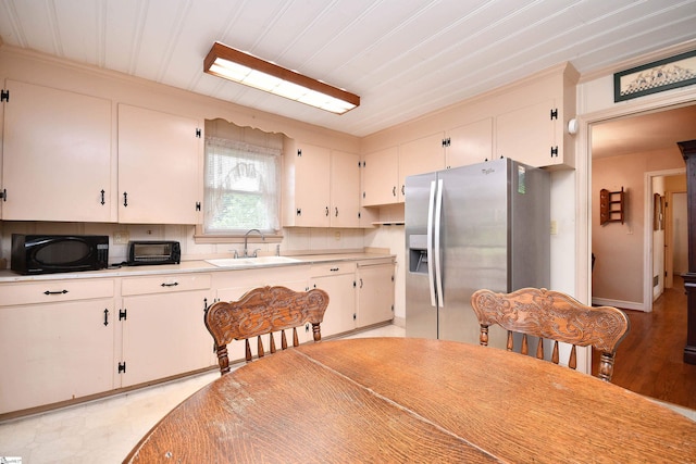 204 Jasper St, Easley, SC 29640 - kitchen featuring stainless steel refrigerator with ice dispenser, black microwave, light countertops, crown molding, and backsplash