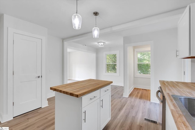 721 Central St, Iva, SC 29655 - kitchen featuring butcher block counters, light wood finished floors, white cabinetry, decorative light fixtures, and stainless steel dishwasher