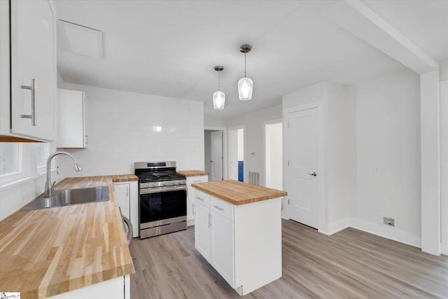 721 Central St, Iva, SC 29655 - kitchen with wood counters, stainless steel gas stove, light wood-type flooring, white cabinetry, and backsplash