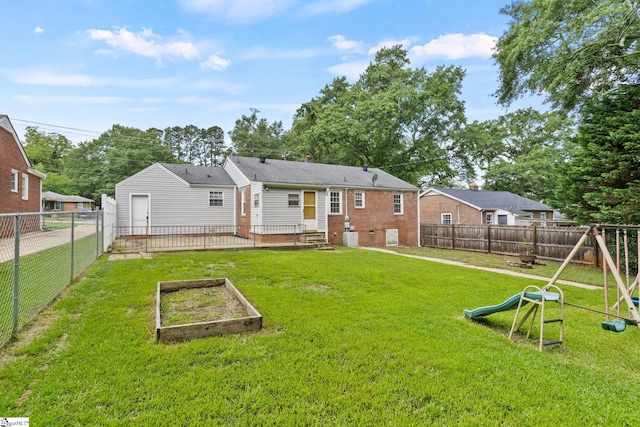 2608 Lane Ave, Anderson, SC 29621 - rear view of house featuring a playground, a vegetable garden, a fenced backyard, and brick siding