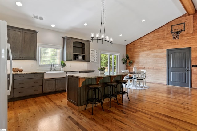 19 Merritt View Ter, Greenville, SC 29609 - kitchen featuring wooden walls, light wood-type flooring, a kitchen breakfast bar, open shelves, and light stone counters