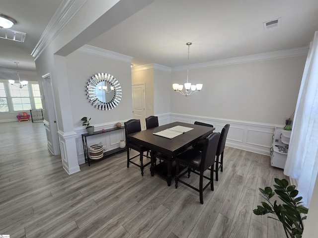 406 Willow Grove Way, Anderson, SC 29631 - dining space with a chandelier, wood finished floors, wainscoting, ornamental molding, and a decorative wall