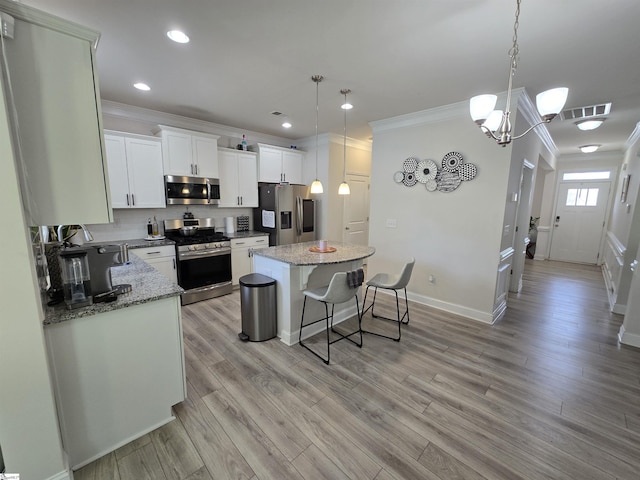 406 Willow Grove Way, Anderson, SC 29631 - kitchen with stainless steel appliances, ornamental molding, a kitchen island, a kitchen bar, and white cabinetry