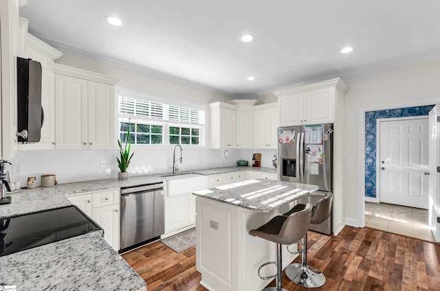 304 Camperdown Ct, Easley, SC 29642 - kitchen featuring stainless steel appliances, white cabinetry, dark wood-style flooring, ornamental molding, and a breakfast bar area
