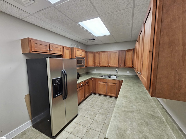 632 Lookover Dr, Anderson, SC 29621 - kitchen with stainless steel appliances, brown cabinets, a drop ceiling, light countertops, and light tile patterned floors