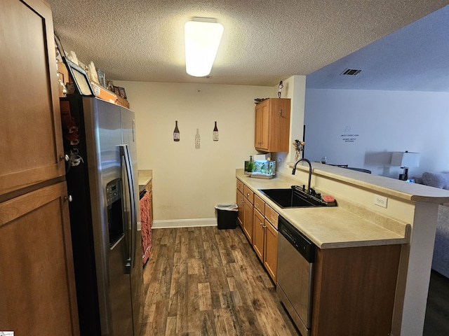 632 Lookover Dr, Anderson, SC 29621 - kitchen with stainless steel appliances, a textured ceiling, dark wood-style flooring, a peninsula, and light countertops