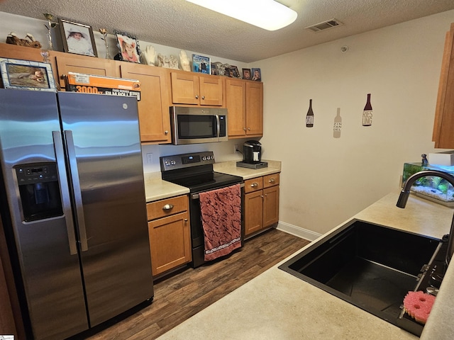 632 Lookover Dr, Anderson, SC 29621 - kitchen with appliances with stainless steel finishes, dark wood finished floors, light countertops, a textured ceiling, and brown cabinets