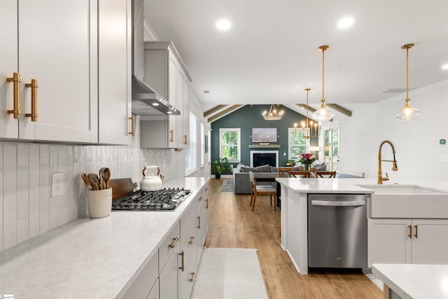 349 Encampment Blvd, Simpsonville, SC 29681 - kitchen featuring appliances with stainless steel finishes, wall chimney range hood, light countertops, tasteful backsplash, and light wood-style floors