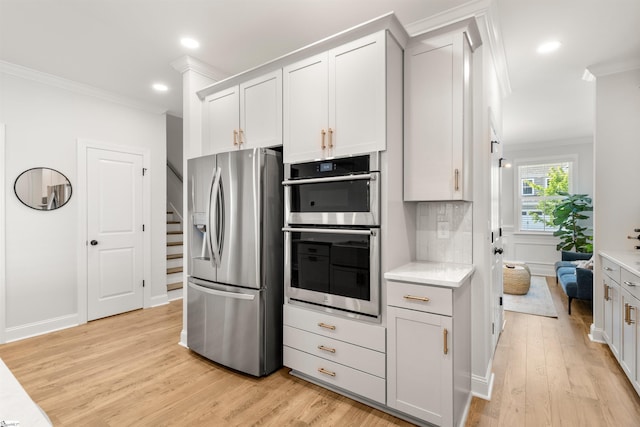 349 Encampment Blvd, Simpsonville, SC 29681 - kitchen featuring stainless steel appliances, ornamental molding, light wood-style floors, light countertops, and backsplash