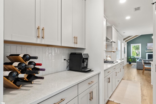 349 Encampment Blvd, Simpsonville, SC 29681 - kitchen featuring tasteful backsplash, light wood-style floors, light countertops, stainless steel gas stovetop, and white cabinets
