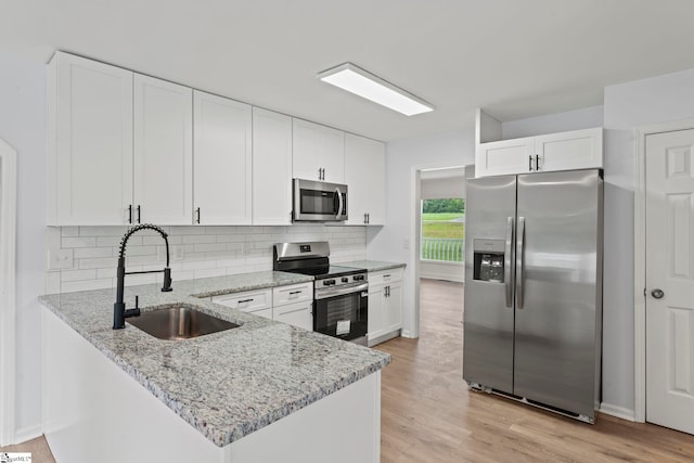 2005 Gap Creek Rd, Greer, SC 29651 - kitchen with appliances with stainless steel finishes, a peninsula, white cabinetry, tasteful backsplash, and light stone countertops