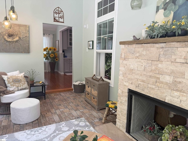 9 Kenton Finch Ct, Simpsonville, SC 29681 - living room with a stone fireplace, brick patterned flooring, and a high ceiling