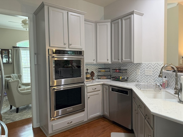 9 Kenton Finch Ct, Simpsonville, SC 29681 - kitchen with appliances with stainless steel finishes, wood finished floors, ceiling fan, gray cabinets, and decorative backsplash