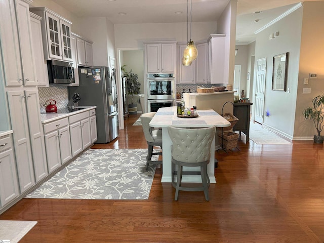 9 Kenton Finch Ct, Simpsonville, SC 29681 - kitchen featuring stainless steel appliances, backsplash, glass insert cabinets, hanging light fixtures, and wood finished floors