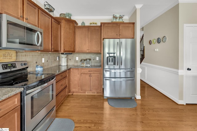 112 Friesian Ct, Pelzer, SC 29669 - kitchen with stainless steel appliances, crown molding, light stone countertops, tasteful backsplash, and light wood-type flooring