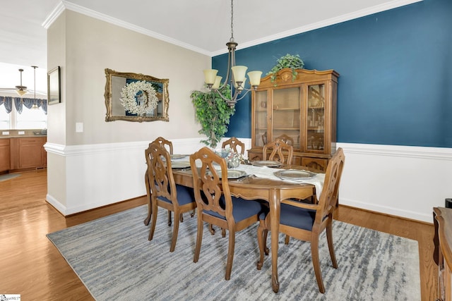 112 Friesian Ct, Pelzer, SC 29669 - dining space with a chandelier, wood finished floors, ornamental molding, and a wainscoted wall