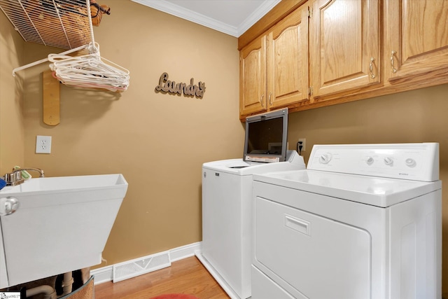14 Quail Meadow Ln, Greenville, SC 29617 - laundry room with separate washer and dryer, cabinet space, ornamental molding, and light wood-type flooring
