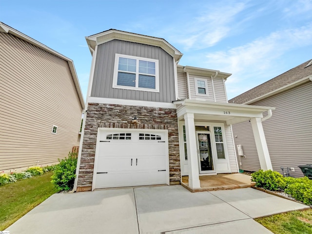 163 Highland Park Ct, Easley, SC 29642 - view of front of home with stone siding, driveway, board and batten siding, a garage, and covered porch