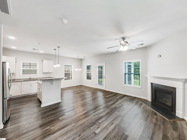 163 Highland Park Ct, Easley, SC 29642 - kitchen with freestanding refrigerator, open floor plan, a glass covered fireplace, dark wood-style flooring, and white cabinetry