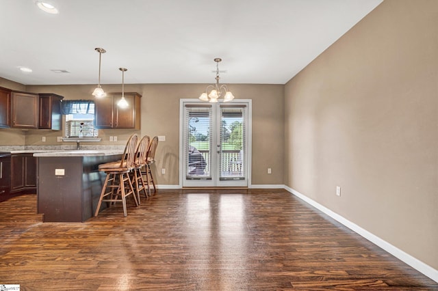102 Tea Leaf Ct, Anderson, SC 29626 - kitchen featuring dark wood finished floors, a kitchen breakfast bar, light countertops, a peninsula, and decorative light fixtures