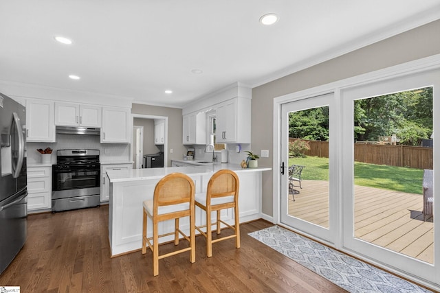 103 W Shallowstone Rd, Greer, SC 29650 - kitchen with stainless steel appliances, under cabinet range hood, a peninsula, light countertops, and white cabinets