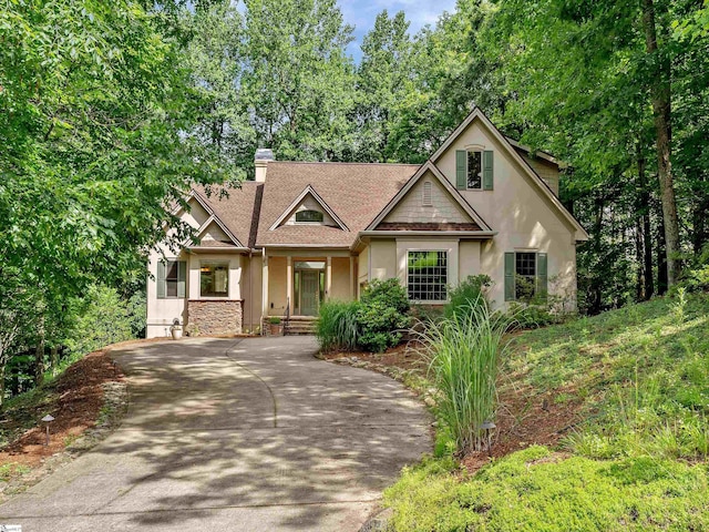 1 Touch Me Not Trl, Landrum, SC 29356 - craftsman house featuring stucco siding, a chimney, concrete driveway, roof with shingles, and covered porch