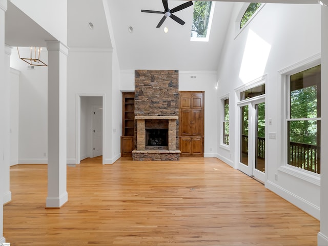 1 Touch Me Not Trl, Landrum, SC 29356 - unfurnished living room featuring high vaulted ceiling, ceiling fan, light wood-type flooring, a stone fireplace, and a skylight