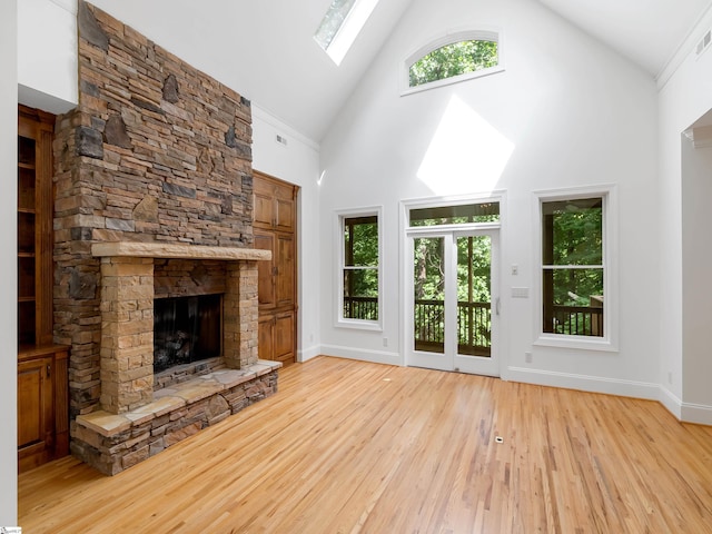 1 Touch Me Not Trl, Landrum, SC 29356 - unfurnished living room with a skylight, high vaulted ceiling, light wood-type flooring, and a stone fireplace